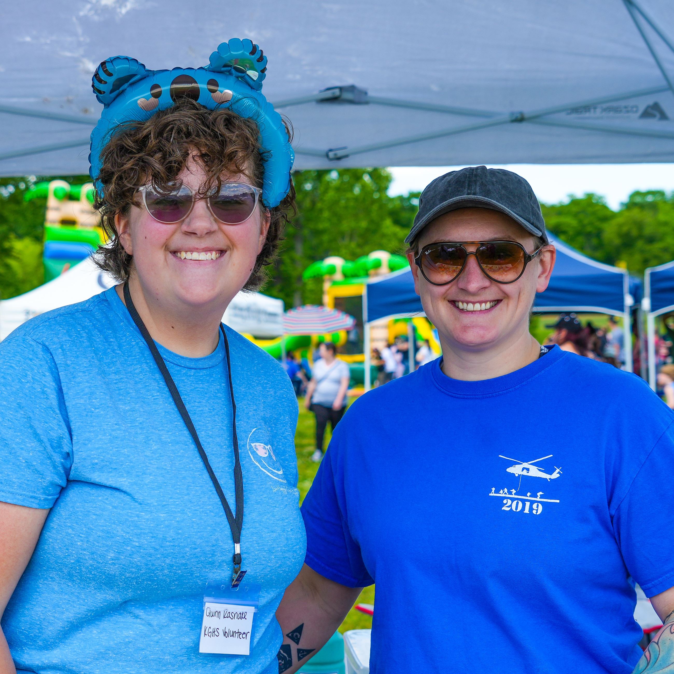Two staffers posing in front of their vendor booth