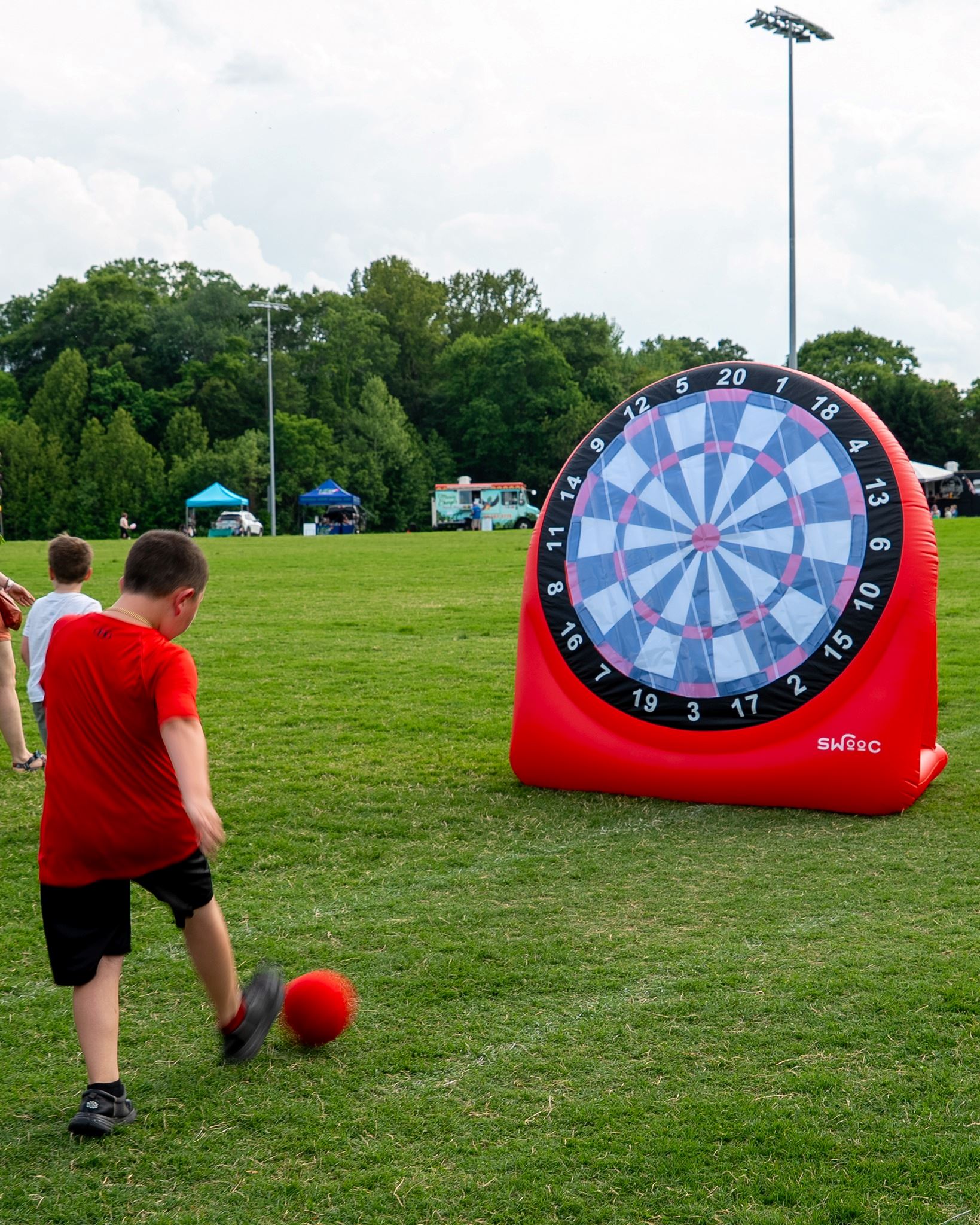 A boy kicking a ball at a large target.